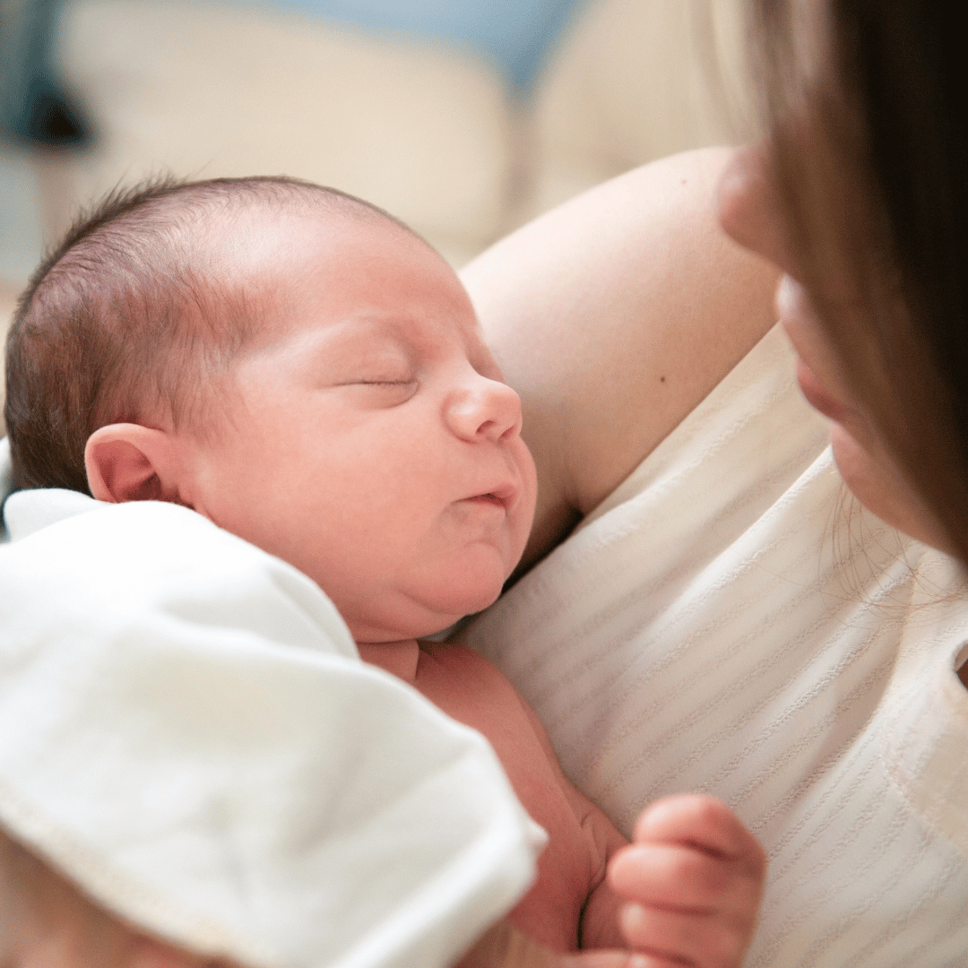 A newborn baby sleeping on their mother's chest